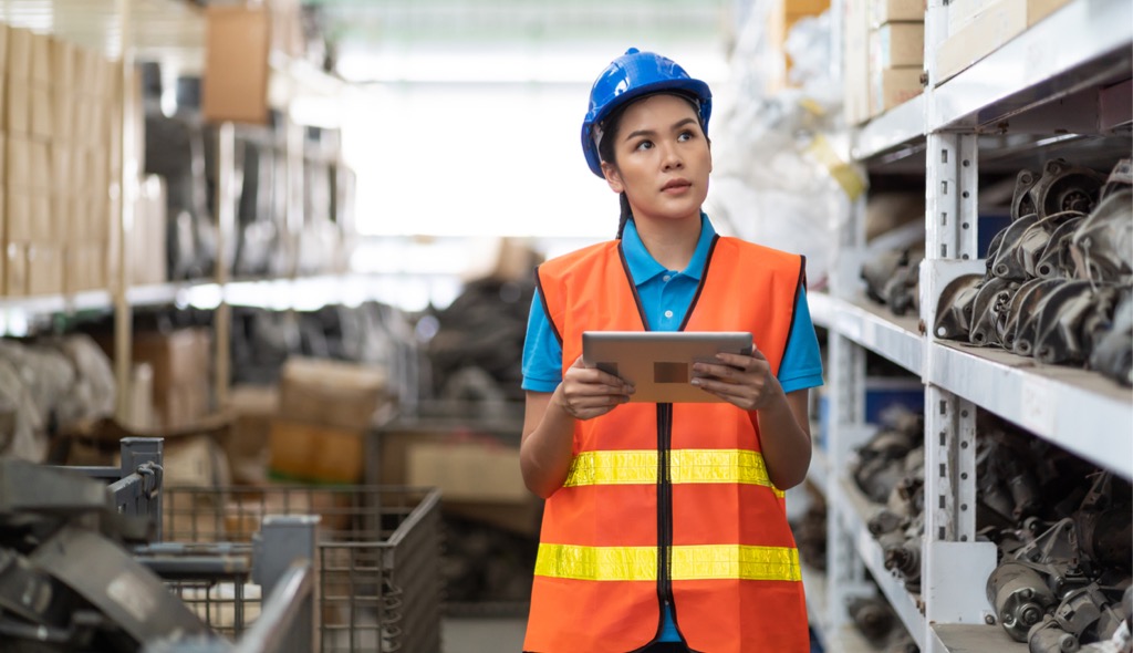 Factory worker checking spare parts warehouse