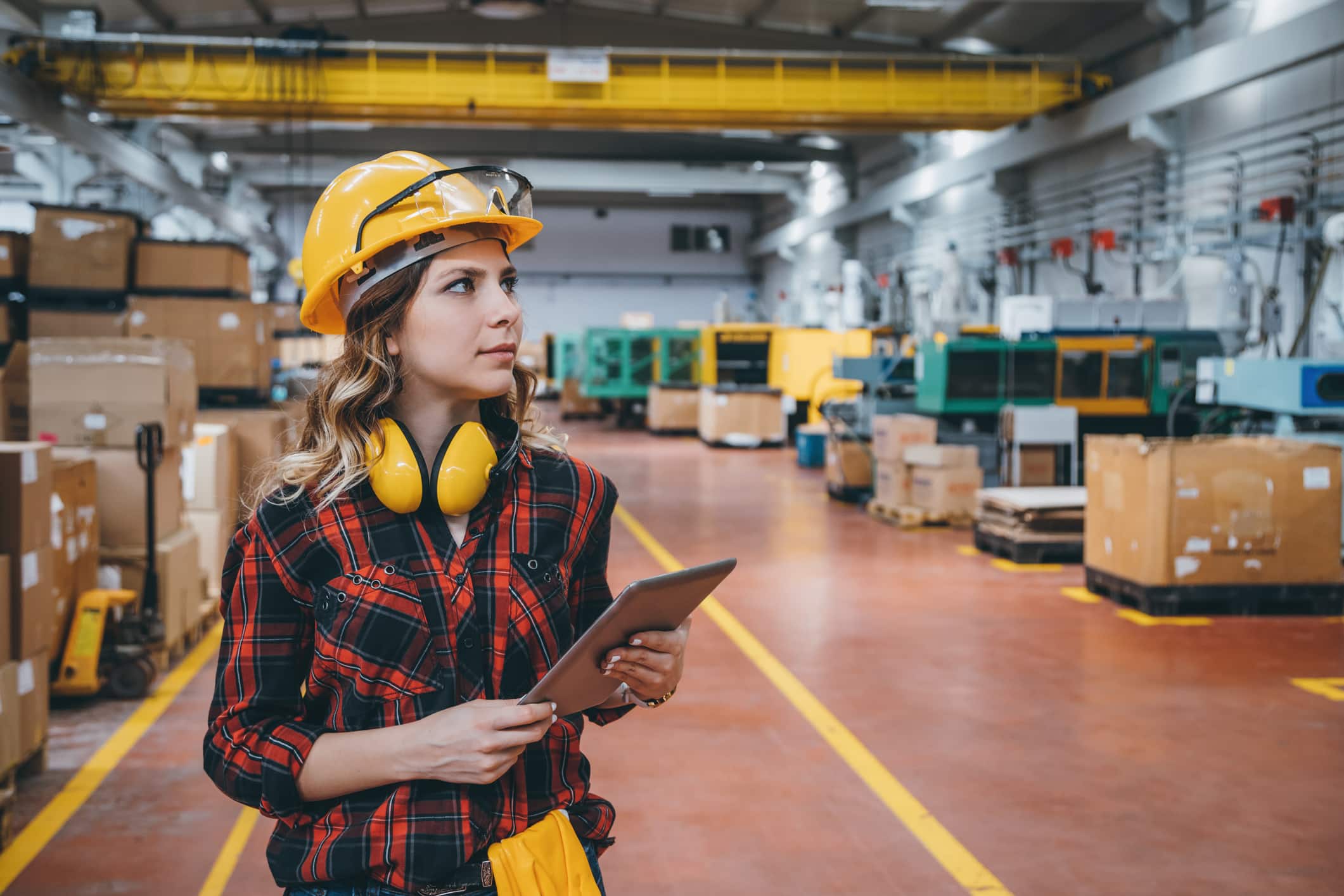 A woman in a high-tech warehouse is looking at a tablet.